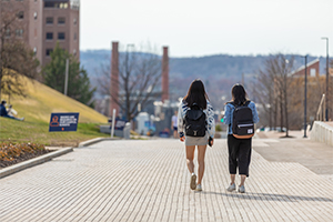 Two students walk on the Einhorn Family Walkway